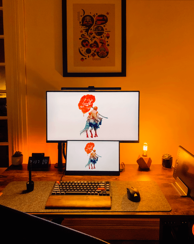 This gaming setup makes use of a fireside aesthetic, with a warm orange as the predominant color. The orange accents on the keyboard bring this gaming setup together and make it feel cohesive across the entire room. 